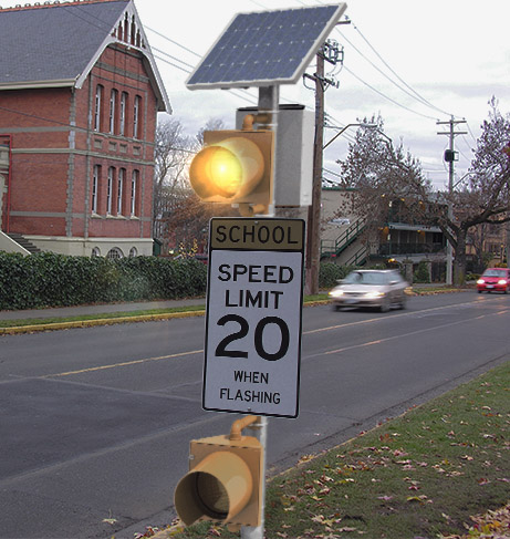 Closeup view of solar-powered school zone traffic beacon with amber flashing light above speed limit sign