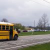 solar-powered school zone speed limit sign beacon and school bus passing by