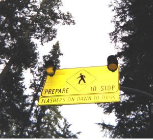 Hanging sign for drivers to prepare to stop with two flashing lights on it.