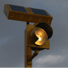 Amber round beacon with a solar engine on a pole at night.