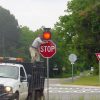 contractor installing solar-powered 24-hour flashing stop sign beacon