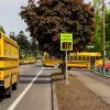 speedcheck radar sign and school buses pulling into school at a school in tigard, oregon