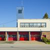 firehall with four red doors and a flag pole